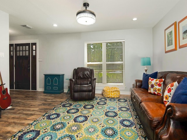 living room with baseboards, visible vents, wood finished floors, and recessed lighting