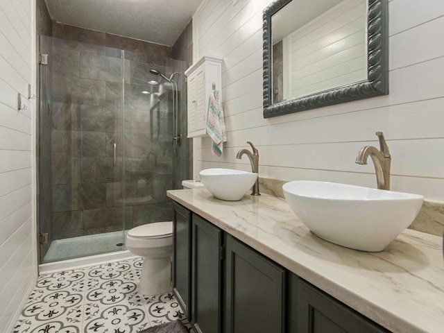 bathroom featuring double vanity, a stall shower, tile patterned flooring, and a sink