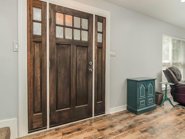 foyer with baseboards and wood finished floors