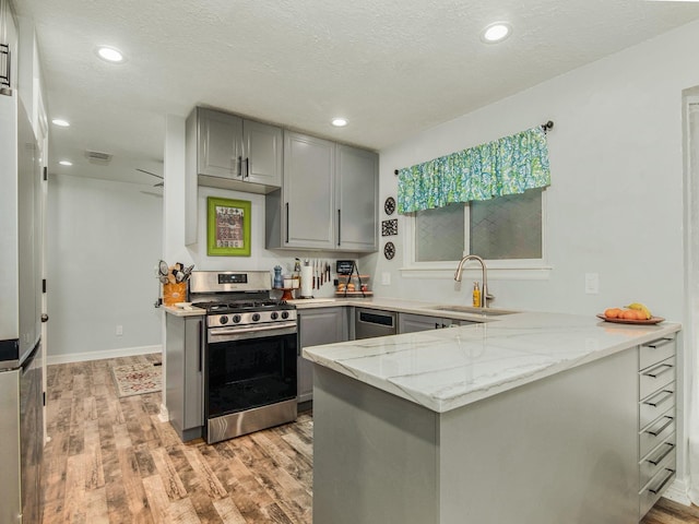 kitchen featuring stainless steel appliances, visible vents, a sink, and gray cabinetry