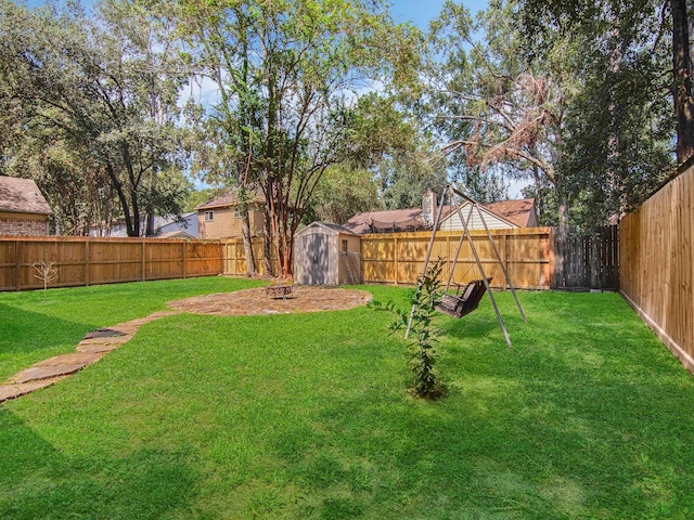 view of yard with a fenced backyard, an outdoor structure, and a storage unit