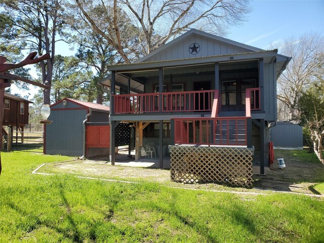 back of property with board and batten siding, an outbuilding, a yard, and a storage unit