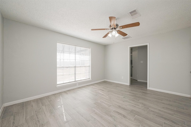 unfurnished room with visible vents, light wood-style flooring, and baseboards