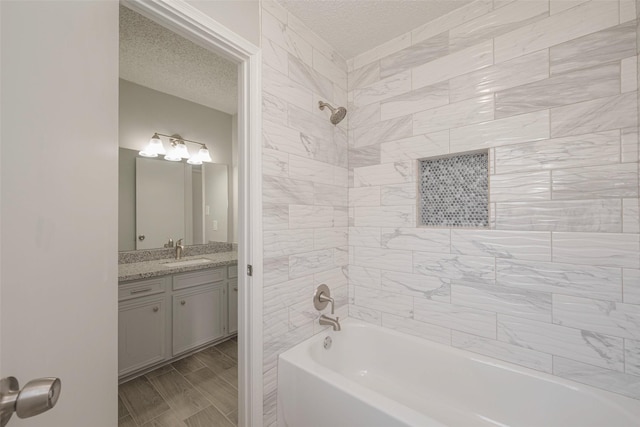 bathroom featuring vanity, wood finish floors, a textured ceiling, and shower / bathtub combination