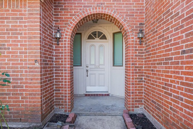 doorway to property featuring brick siding