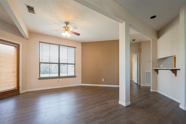 unfurnished room with dark wood-type flooring, visible vents, and baseboards