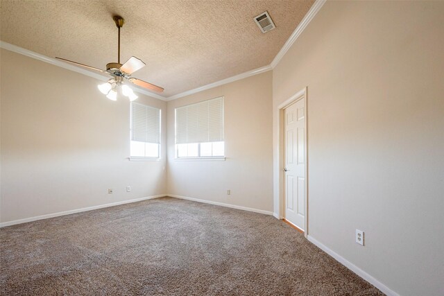 unfurnished room with baseboards, carpet floors, visible vents, and crown molding