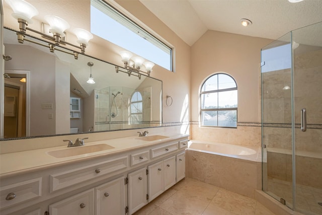 full bathroom featuring double vanity, a stall shower, lofted ceiling, a bath, and a sink