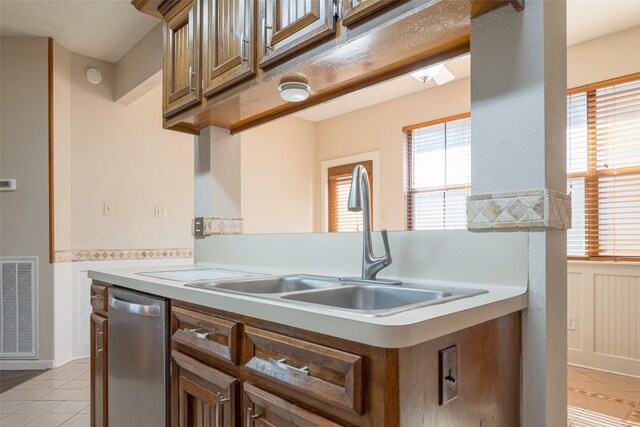 kitchen featuring light tile patterned floors, visible vents, light countertops, stainless steel dishwasher, and a sink