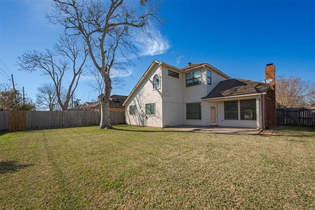 rear view of house featuring a fenced backyard, a chimney, a patio, and a yard