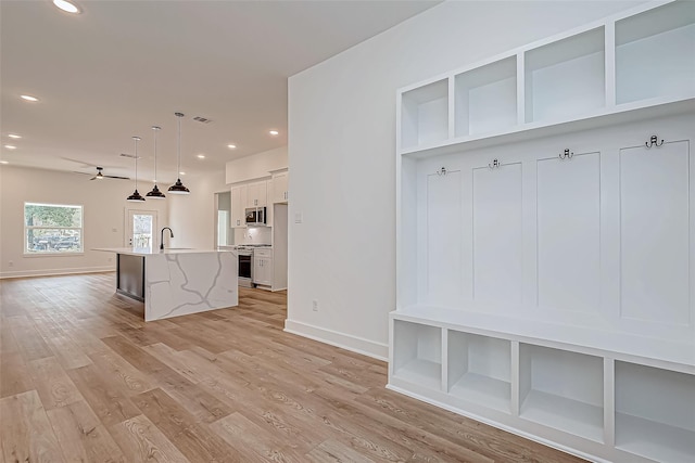 mudroom featuring light wood finished floors, recessed lighting, a sink, ceiling fan, and baseboards