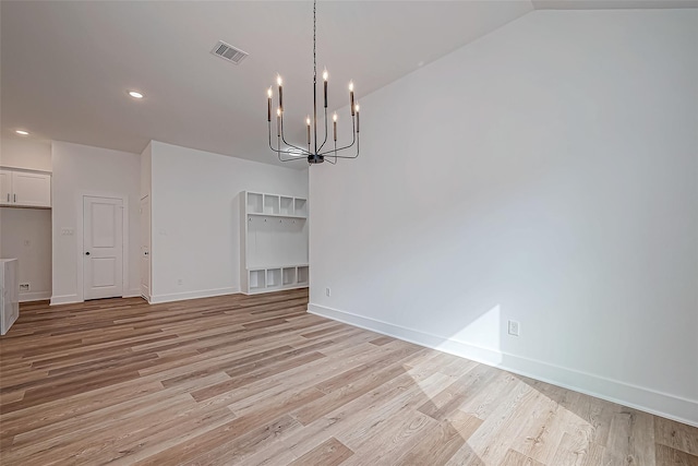 unfurnished dining area with light wood finished floors, baseboards, visible vents, and a chandelier