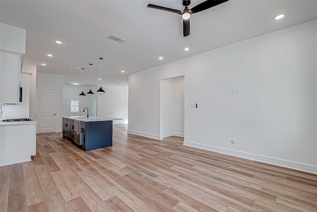 kitchen featuring recessed lighting, light countertops, light wood-style flooring, a ceiling fan, and a sink