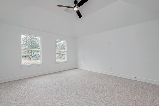 spare room featuring vaulted ceiling, light carpet, visible vents, and a ceiling fan