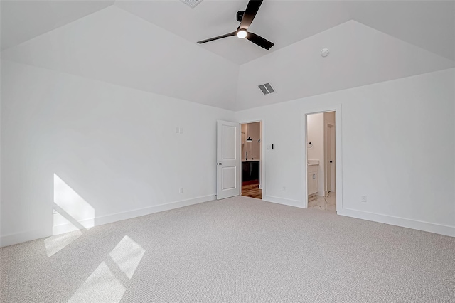 unfurnished bedroom with lofted ceiling, ensuite bathroom, light carpet, visible vents, and baseboards