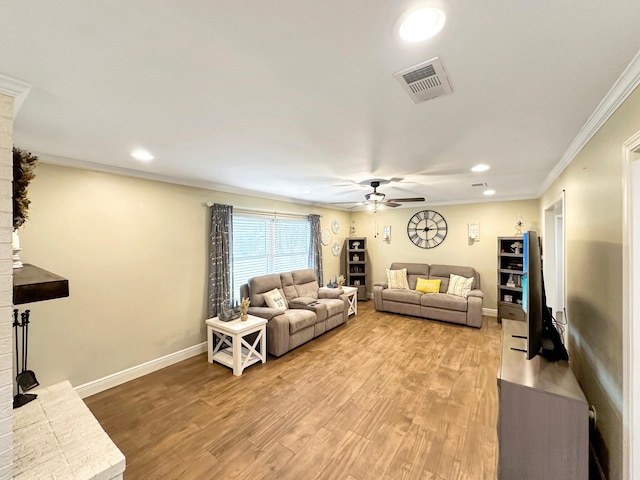 living room with ceiling fan, visible vents, baseboards, light wood-style floors, and crown molding