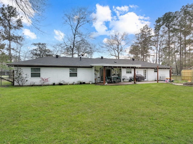 back of property with a lawn, a gate, a patio area, fence, and a garage