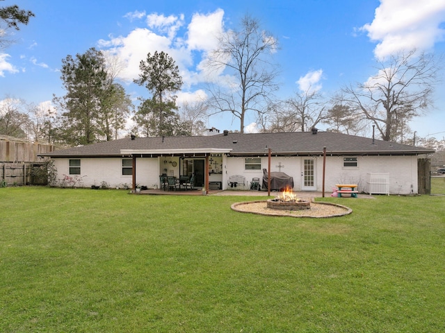 back of house with fence, a fire pit, a lawn, and a patio