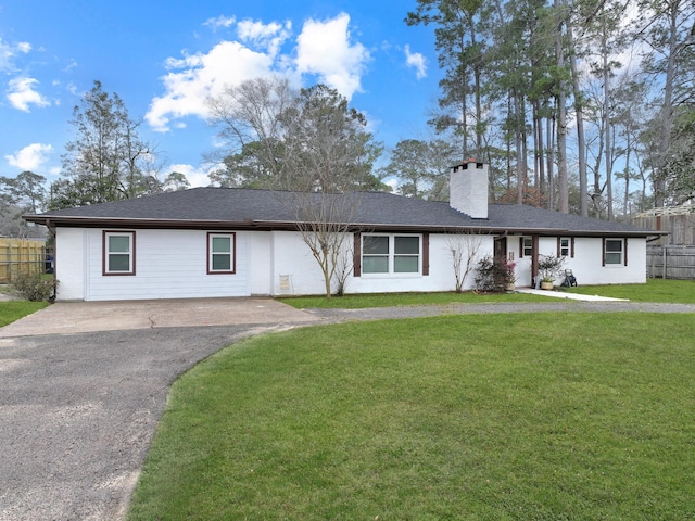 ranch-style home featuring aphalt driveway, a shingled roof, fence, a front lawn, and a chimney