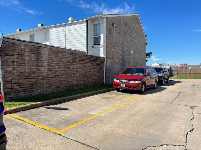 uncovered parking lot featuring fence