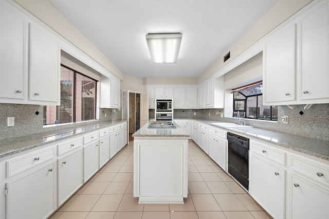 kitchen with white cabinetry, a sink, dishwasher, and light tile patterned floors