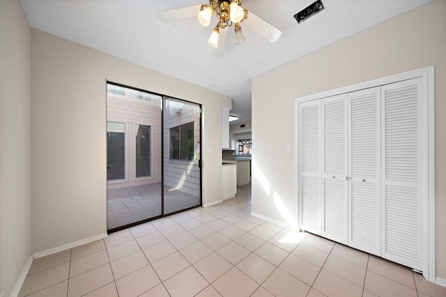 interior space with access to outside, ceiling fan, a closet, and light tile patterned flooring