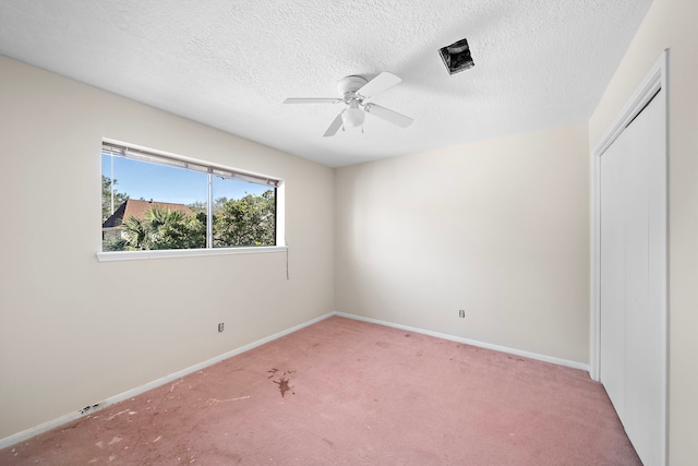 unfurnished bedroom with a ceiling fan, carpet flooring, a textured ceiling, and baseboards