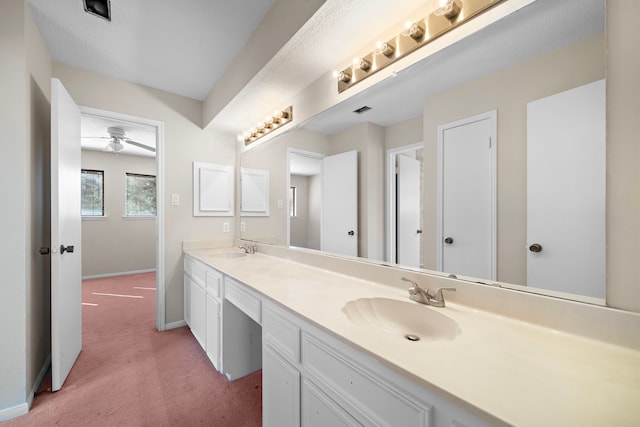 bathroom featuring visible vents, a sink, baseboards, and double vanity