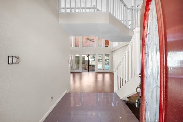 hall with stairs, a high ceiling, and baseboards