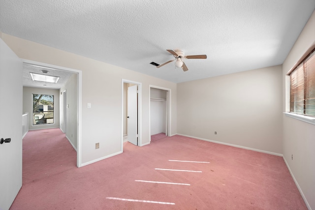 unfurnished bedroom featuring carpet floors, attic access, baseboards, and a textured ceiling