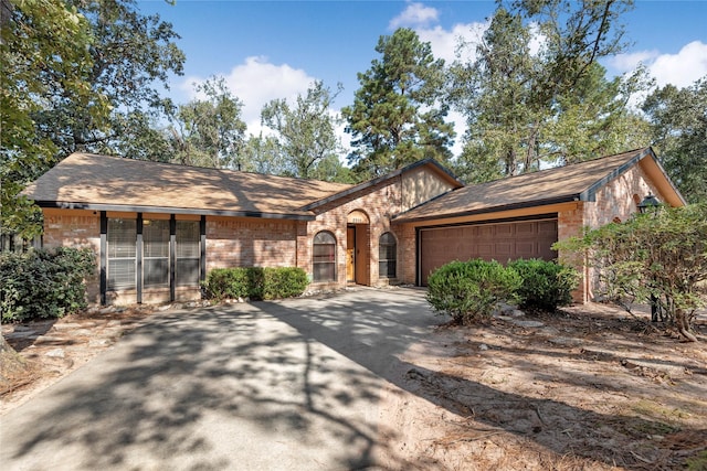 view of front of house with a garage, driveway, and brick siding