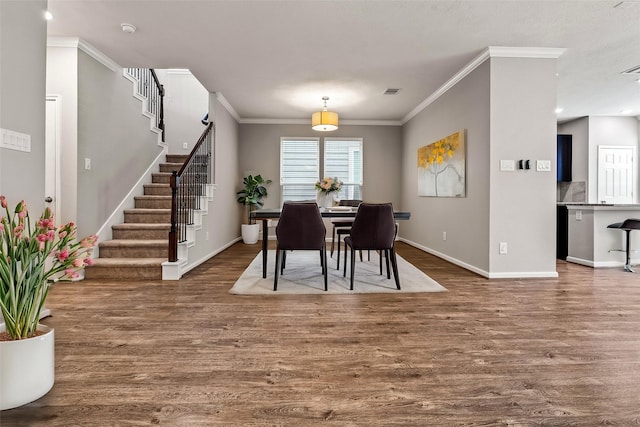 dining area with baseboards, stairs, ornamental molding, and wood finished floors