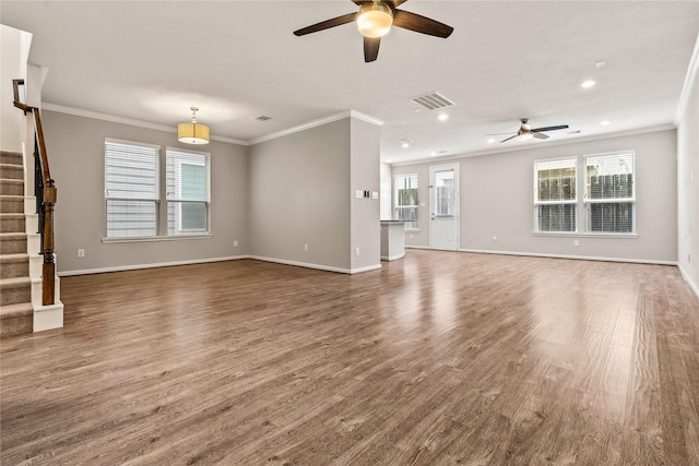 unfurnished living room featuring visible vents, stairway, ornamental molding, wood finished floors, and baseboards