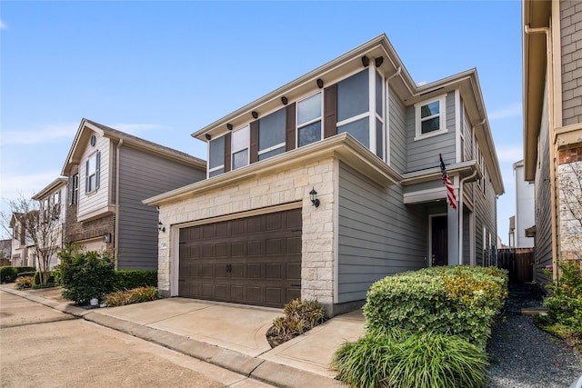 view of front of property featuring concrete driveway, stone siding, and an attached garage