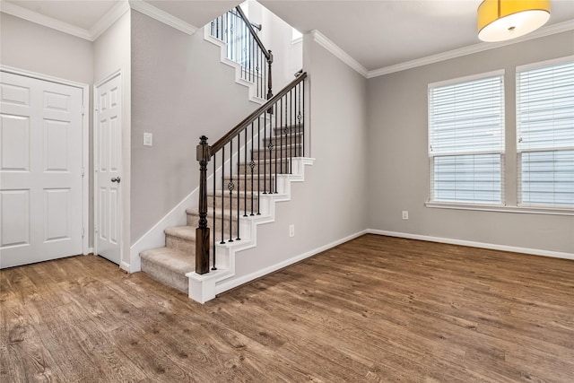 entryway with ornamental molding, stairs, baseboards, and wood finished floors