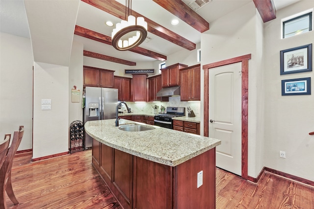 kitchen with stainless steel appliances, backsplash, light wood-style floors, a sink, and under cabinet range hood