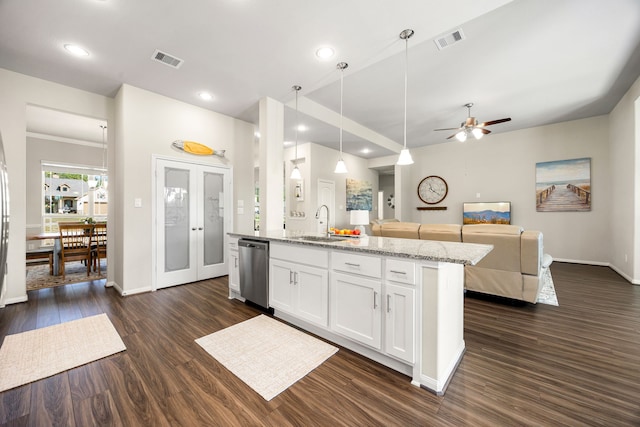 kitchen featuring a sink, visible vents, white cabinets, open floor plan, and dishwasher