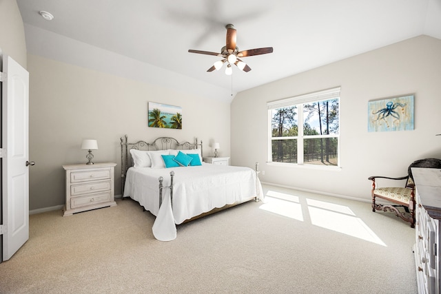 bedroom with vaulted ceiling, light carpet, and baseboards