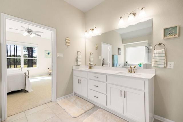 ensuite bathroom featuring a sink, a ceiling fan, baseboards, tile patterned floors, and double vanity