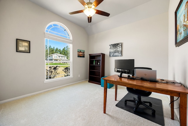 carpeted office space featuring lofted ceiling, ceiling fan, and baseboards