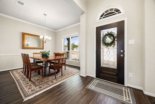 foyer entrance featuring visible vents, baseboards, ornamental molding, dark wood-style flooring, and a chandelier