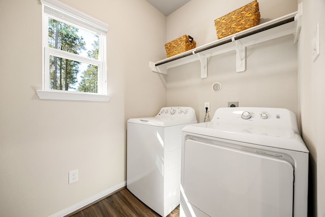 clothes washing area featuring dark wood-style floors, washing machine and dryer, laundry area, and baseboards