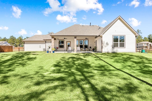 rear view of house with ceiling fan, fence, a lawn, and a patio