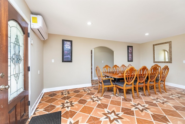 dining space with arched walkways, recessed lighting, a wall mounted AC, and baseboards