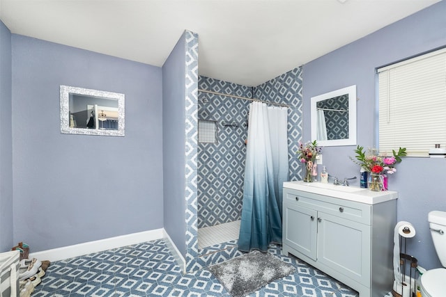 bathroom featuring baseboards, tiled shower, toilet, and vanity