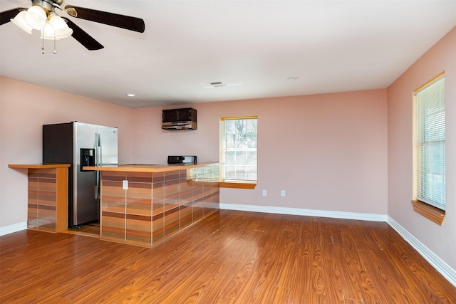 bar with baseboards, wood finished floors, and stainless steel refrigerator with ice dispenser