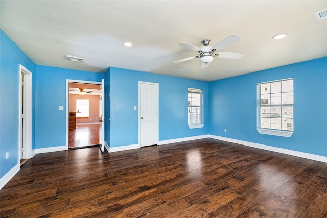 unfurnished bedroom featuring dark wood-style floors, visible vents, and baseboards