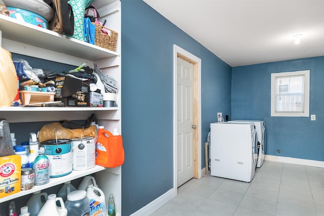 washroom featuring tile patterned flooring, laundry area, baseboards, and separate washer and dryer