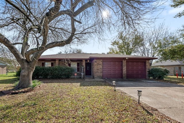 view of front of home with a garage, a front yard, brick siding, and driveway