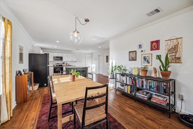 dining area featuring dark wood-style floors, visible vents, crown molding, and baseboards